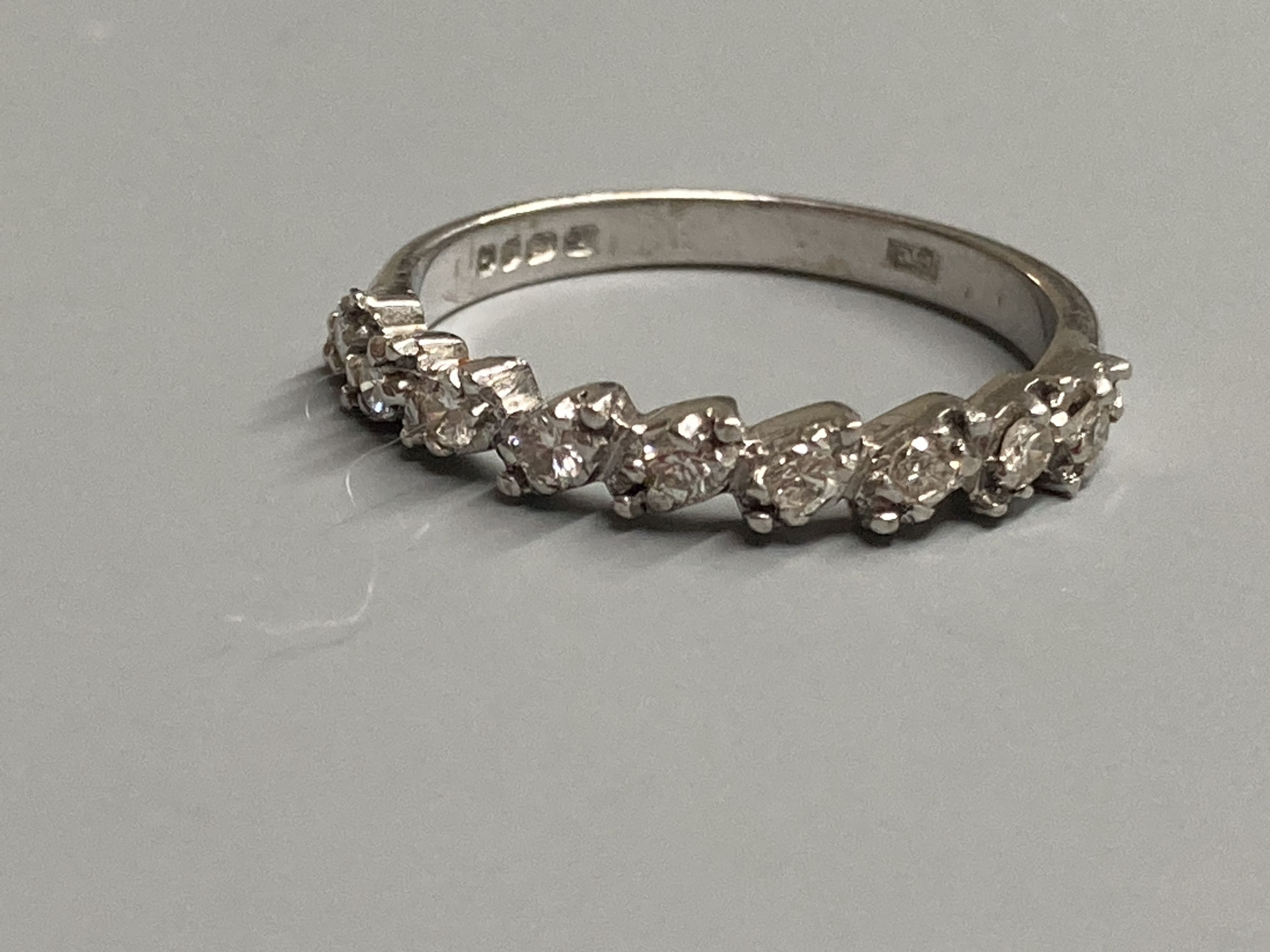 A modern 18ct white gold and nine stone diamond set half eternity ring, size N, gross 3 grams.